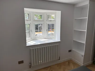 The bay window brings daylight into the new room, with alcove shelving alongside