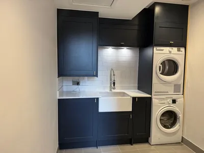 The fitted kitchenette with navy shaker units and a belfast sink