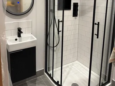 Metro tiling and black brassware in the shower room